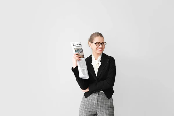 Joven empresaria con periódico sobre fondo claro — Foto de Stock