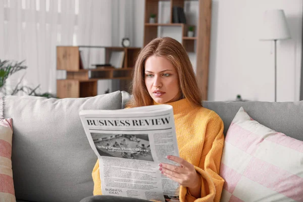 Mujer joven leyendo el periódico en casa — Foto de Stock