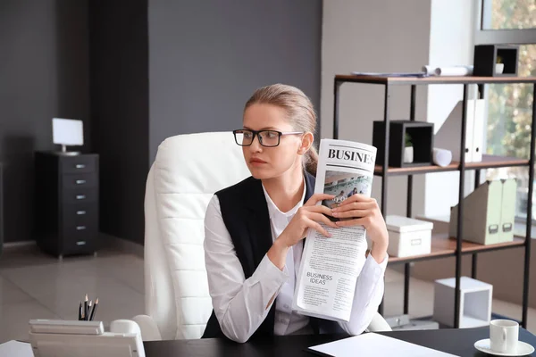 Joven empresaria leyendo periódico en la oficina — Foto de Stock