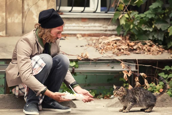 Pobre hombre compartiendo comida con gato sin hogar al aire libre —  Fotos de Stock