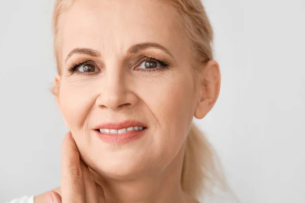 Porträt der schönen reifen Frau auf hellem Hintergrund — Stockfoto