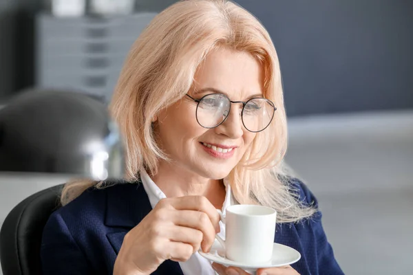 Mulher de negócios madura bebendo café no escritório — Fotografia de Stock