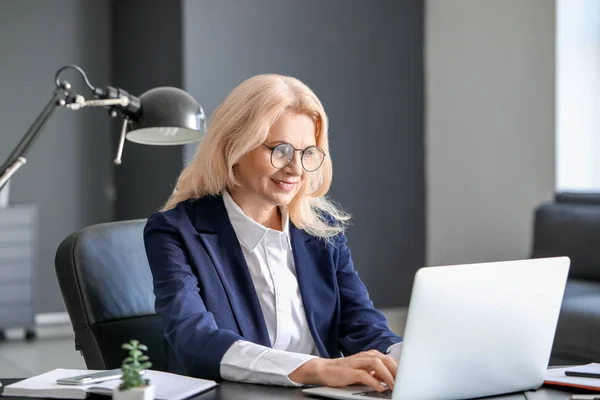 Madura mujer de negocios que trabaja en el ordenador portátil en la oficina —  Fotos de Stock