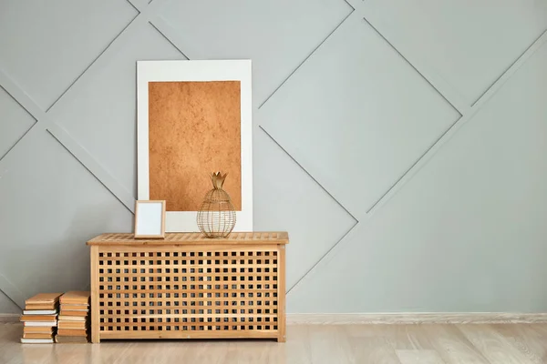 Wooden chest with books and decor near grey wall in room — Stock Photo, Image