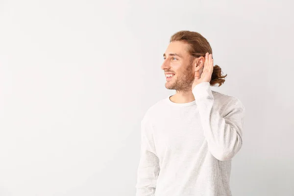Hombre joven con audífono sobre fondo blanco — Foto de Stock