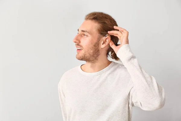 Młody człowiek z aparatem słuchowym na białym tle — Zdjęcie stockowe