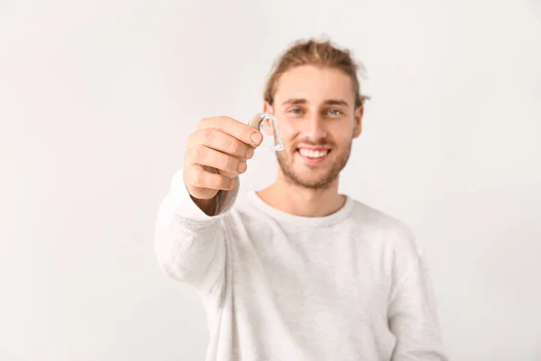 Hombre joven con audífono sobre fondo blanco — Foto de Stock