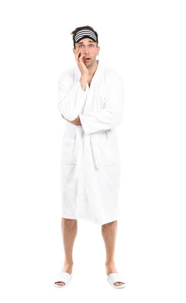 Emotional man in bathrobe and sleep mask on white background — Stock Photo, Image