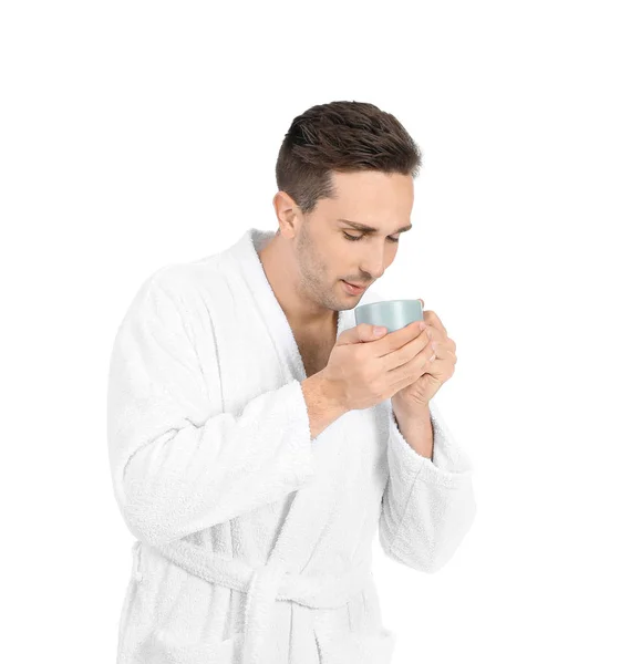 Homem bonito em roupão de banho e com xícara de café no fundo branco — Fotografia de Stock