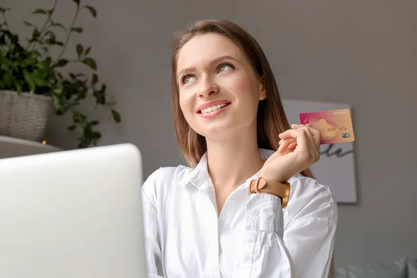 Jeune femme avec carte de crédit et achats informatiques en ligne à la maison — Photo