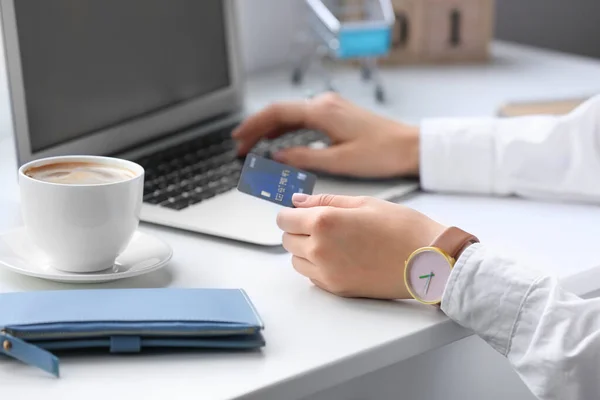 Молода жінка з кредитною карткою та покупками комп'ютерів онлайн вдома — стокове фото