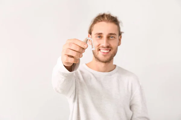 Jonge man met gehoorapparaat op witte achtergrond Stockafbeelding