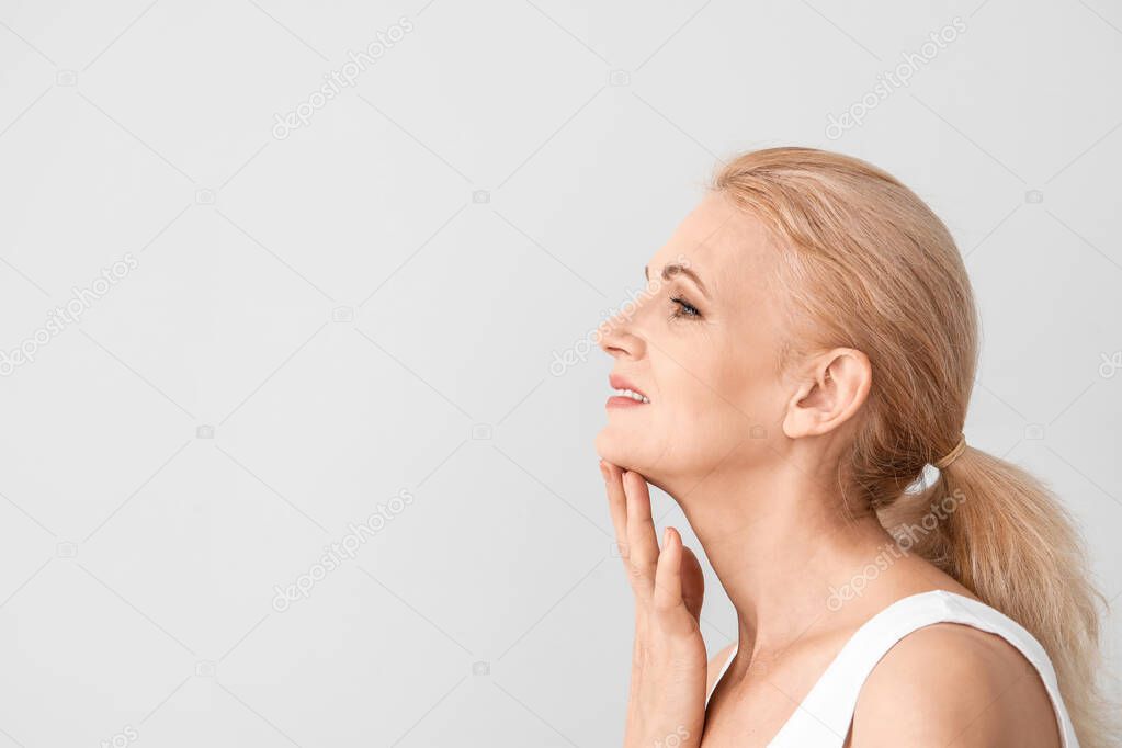 Portrait of beautiful mature woman on light background