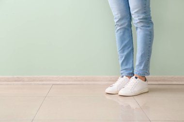 Renkli duvarın yanında şık ayakkabılı genç adam.