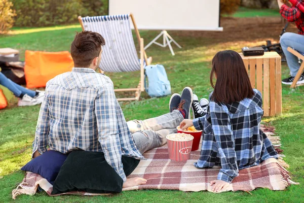 Young couple watching movie in outdoor cinema — Stock Photo, Image