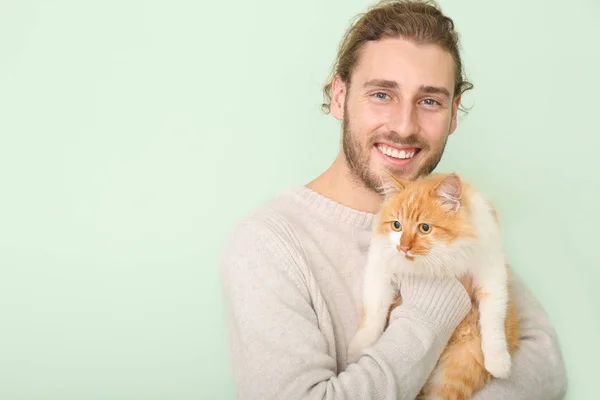 Uomo con gatto carino su sfondo di colore — Foto Stock