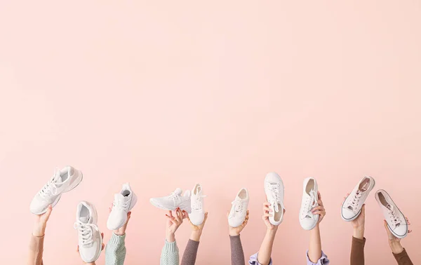 Molte mani con diverse scarpe eleganti su sfondo di colore — Foto Stock