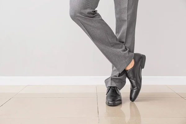Young man in elegant shoes near light wall — Stock Photo, Image