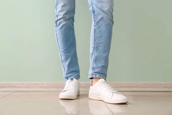 Hombre joven en zapatos elegantes cerca de la pared de color — Foto de Stock