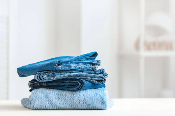 Stack of clean clothes on table in room — Stock Photo, Image