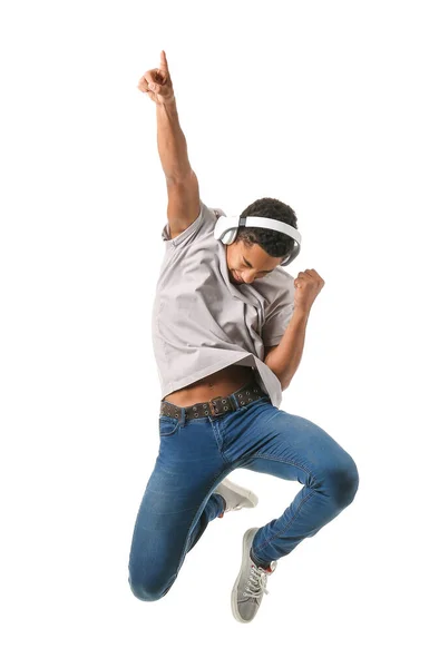 Jumping African-American teenager boy with headphones on white background — Stock Photo, Image