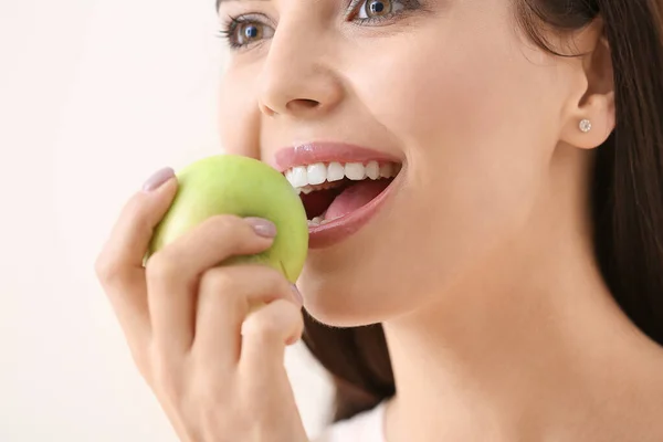 Hermosa joven con manzana fresca sobre fondo claro — Foto de Stock