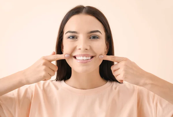 Bella giovane donna con denti sani su sfondo chiaro — Foto Stock