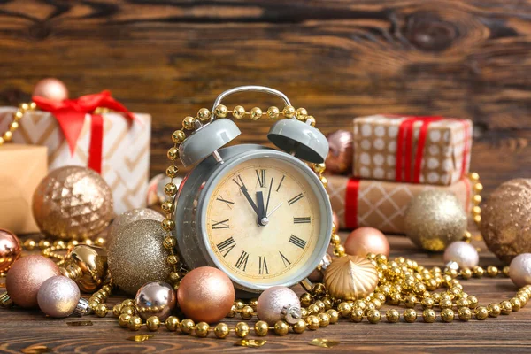 Alarm clock with Christmas decor on wooden background — ストック写真