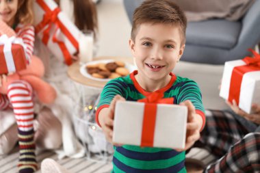 Noel hediyeli küçük çocuk ve ailesi evde.