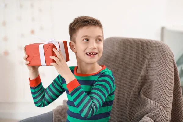 Cute little boy z prezentem świątecznym w domu — Zdjęcie stockowe