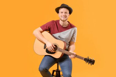 Renkli arka planda gitar çalan yakışıklı adam