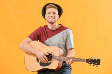 Renkli arka planda gitar çalan yakışıklı adam