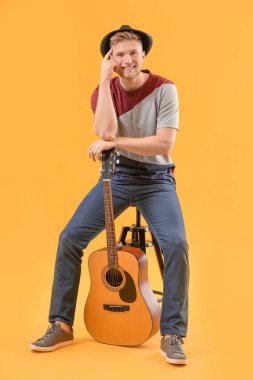 Renkli arka planda gitarı olan yakışıklı adam.