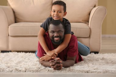 Afro-Amerikan bir adam ve evdeki küçük oğlunun portresi.