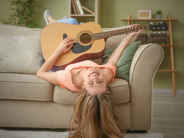 Mooie jonge vrouw met gitaar thuis — Stockfoto