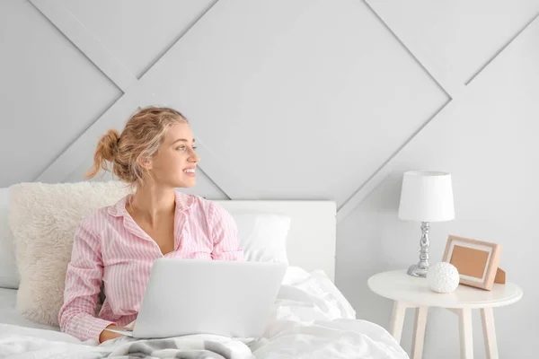 Morning of beautiful young woman with laptop in bed — Stock Photo, Image