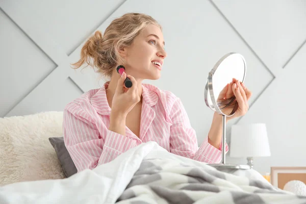 Morning of beautiful young woman applying makeup in bedroom — Stock Photo, Image