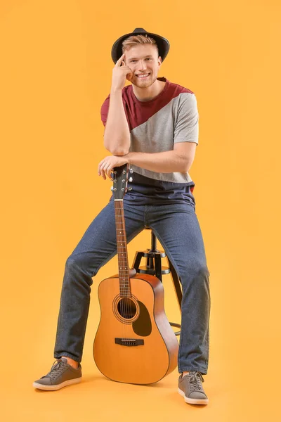Handsome man with guitar on color background — Stock Photo, Image