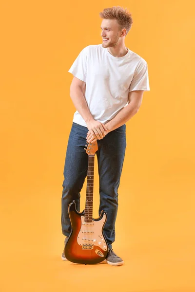 Handsome man with guitar on color background — Stock Photo, Image