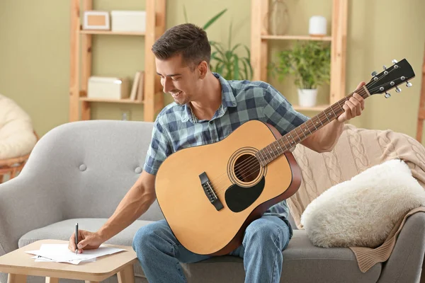 Handsome man with guitar composing music at home — Stock Photo, Image