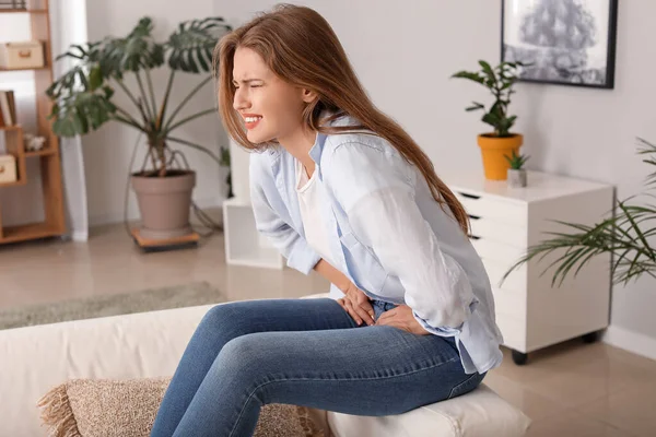 Młoda kobieta cierpiąca na ból brzucha w domu — Zdjęcie stockowe