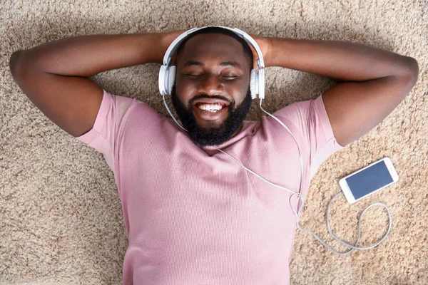 Afroamerikansk man lyssnar på musik hemma, ovanifrån — Stockfoto