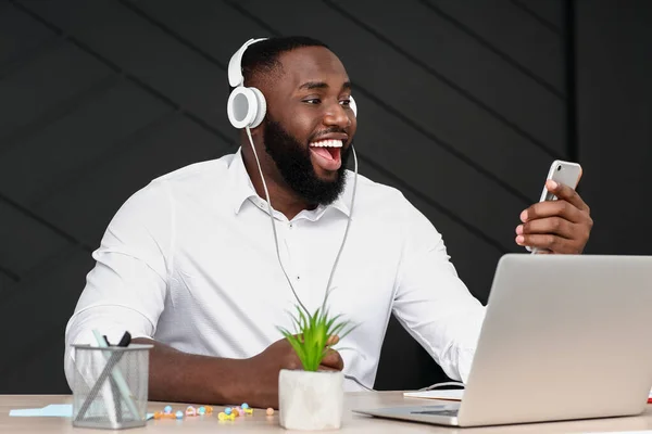 Hombre afroamericano escuchando música en la oficina — Foto de Stock