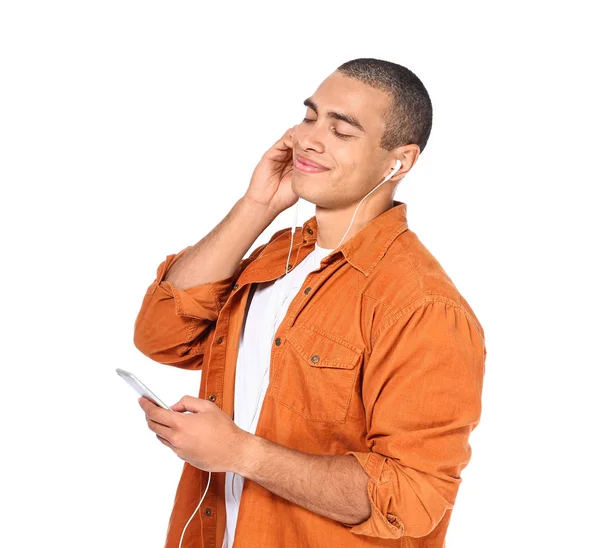 Portret van knappe jongeman luisterend naar muziek op witte achtergrond — Stockfoto