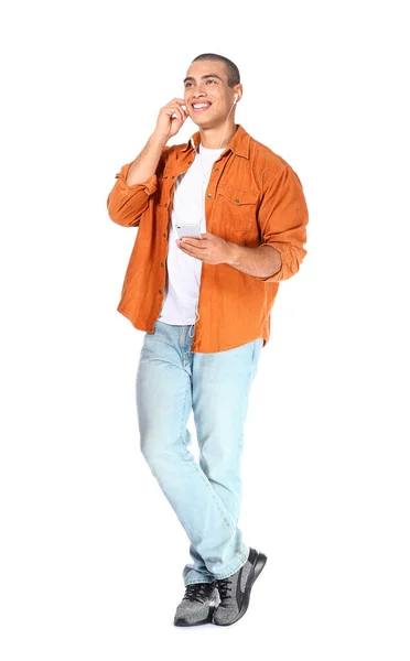 Portrait of handsome young man listening to music on white background — Stock Photo, Image