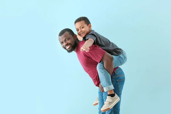 Retrato del hombre afroamericano con su pequeño hijo sobre fondo de color —  Fotos de Stock