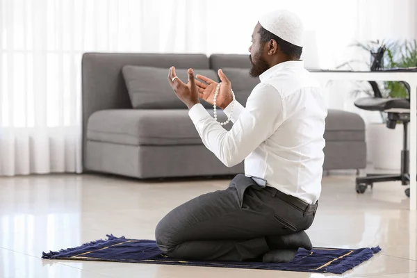 Afroamerykanin muzułmanin modlący się w biurze — Zdjęcie stockowe
