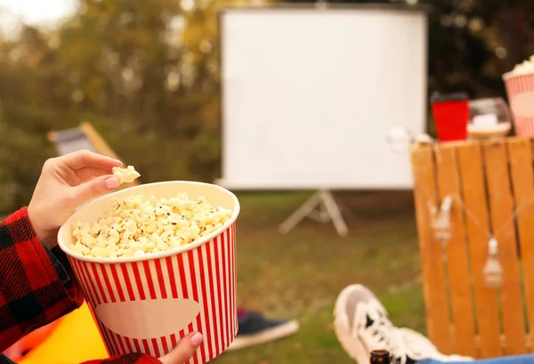 Woman with popcorn watching movie in outdoor cinema — Stock Photo, Image