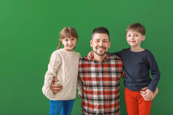 Happy family in winter clothes on color background — Stock Photo, Image