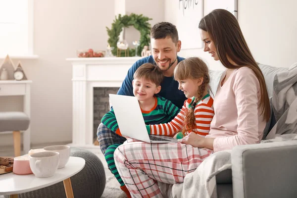 Happy family with laptop resting at home — Stock Photo, Image